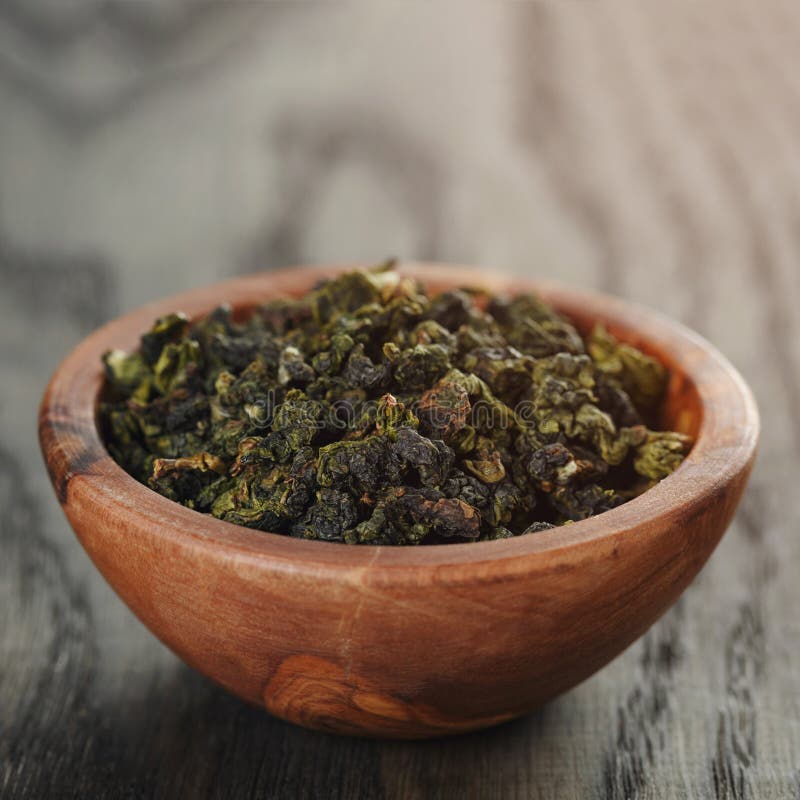 Oolong groene thee in olijfkom stock foto Oolong groene thee in olijfkom stock foto