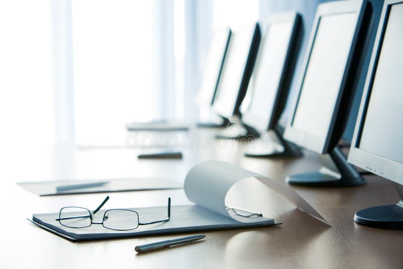 Workplace with open notepad, pen, eyeglasses and monitors on it. Workplace with open notepad, pen, eyeglasses and monitors on it