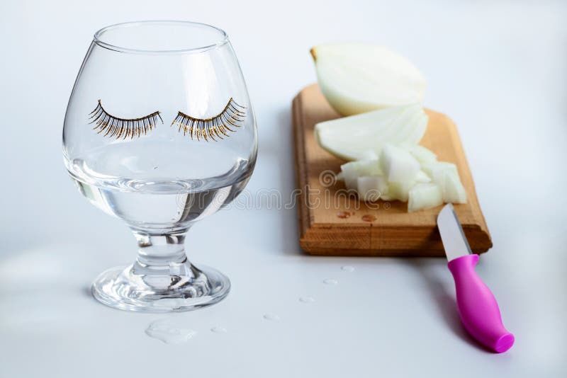 Op de keuken houten scherpe die Raad in stukken wordt gesneden die uien branden Een glas met toegepaste die wimpers met scheuren royalty-vrije stock afbeelding Op de keuken houten scherpe die Raad in stukken wordt gesneden die uien branden Een glas met toegepaste die wimpers met scheuren royalty-vrije stock afbeelding