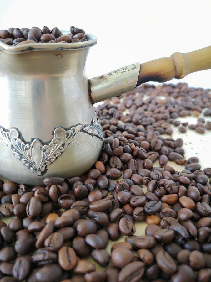 Op de lijst is een cezve, met koffiebonen die wordt gevuld Andere koffiebonen zijn rond verspreid royalty-vrije stock afbeelding Op de lijst is een cezve, met koffiebonen die wordt gevuld Andere koffiebonen zijn rond verspreid royalty-vrije stock afbeelding