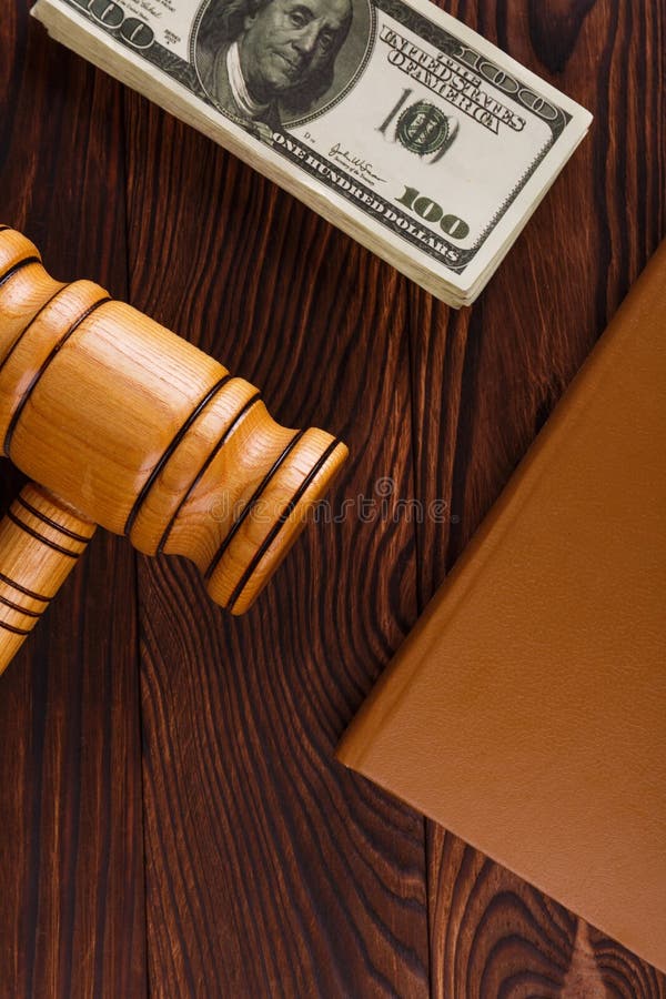 Op de lijst zijn er dollarrekeningen, een veilingmeester` s hamer en een bruine blocnote royalty-vrije stock afbeelding Op de lijst zijn er dollarrekeningen, een veilingmeester` s hamer en een bruine blocnote royalty-vrije stock afbeelding