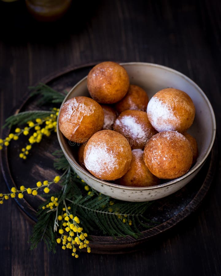 Op een plaat donuts met suikerpoeder, met mimosabloemen die wordt verfraaid Houten achtergrond stock foto's Op een plaat donuts met suikerpoeder, met mimosabloemen die wordt verfraaid Houten achtergrond stock foto's