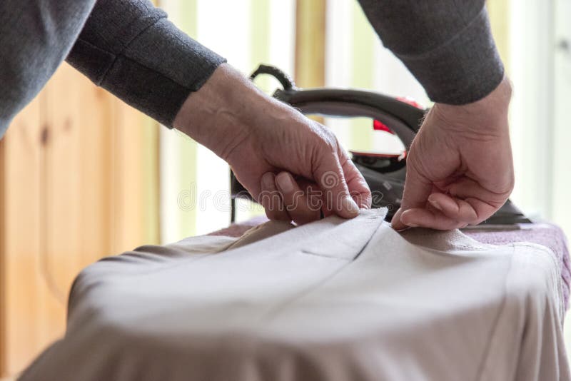 Opahulp het strijken kleding voor oma Nadruk op oude handen royalty-vrije stock afbeeldingen Opahulp het strijken kleding voor oma Nadruk op oude handen royalty-vrije stock afbeeldingen