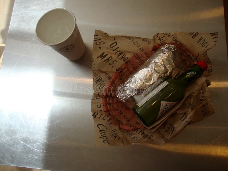 Opakowany Burrito z napojem i zielonym tabasco w Chipotle fotografia stock Opakowany Burrito z napojem i zielonym tabasco w Chipotle fotografia stock