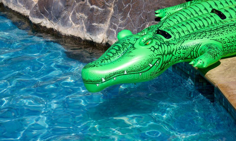 An inflatable child's crocodile at the edge of the pool. An inflatable child's crocodile at the edge of the pool