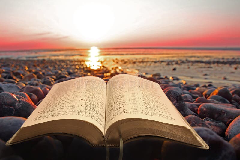 Open bible spiritual light on seashore