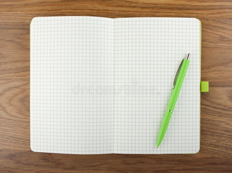 Open blank checked notebook with green pen on a table. royalty free stock photo Open blank checked notebook with green pen on a table. royalty free stock photo