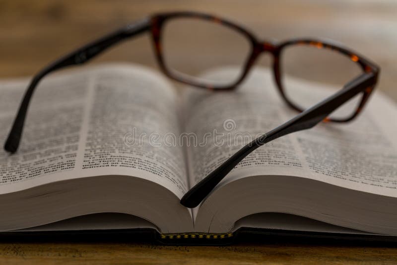 Open boek met glazen op houten bureau, close-up stock foto's Open boek met glazen op houten bureau, close-up stock foto's