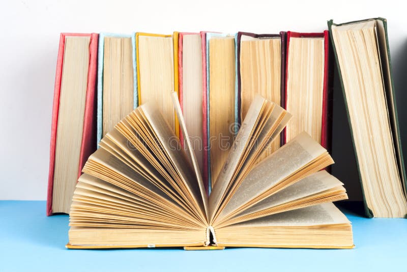 Open book, stack of colorful hardback books on light table. Back to school. Copy space for text stock photos Open book, stack of colorful hardback books on light table. Back to school. Copy space for text stock photos