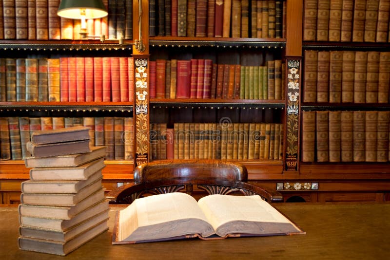 Libro abierto sobre el de madera escritorio próximo sobre el pila de viejo libros en estudiar o biblioteca lleno estantes en.