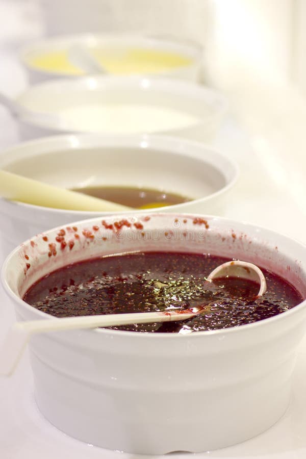 Open buffet at the hotel. Raspberry jam on white bowl with spoon royalty free stock photos