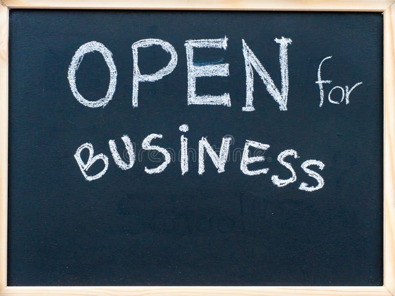 Open for business sign message handwritten with white chalk on on wooden frame blackboard, successful business concept