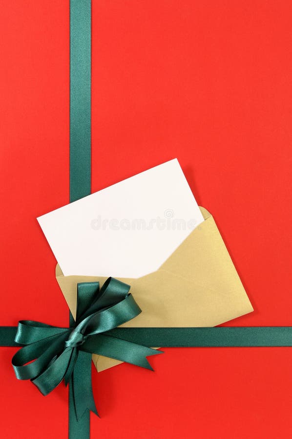 Open Christmas or birthday card with green gift ribbon bow on plain red wrapping paper background, vertical