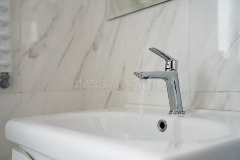 Open chrome faucet water washbasin in bathroom. Modern chrome tap faucet with running water use for background royalty free stock photography Open chrome faucet water washbasin in bathroom. Modern chrome tap faucet with running water use for background royalty free stock photography