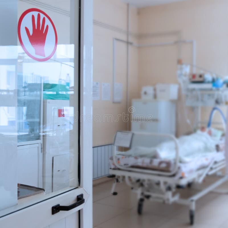 Open door to the intensive care room in the hospital. Shallow depth of field. Blur background. A seriously ill person is lying on a cot. Equipment. Copy space. Open door to the intensive care room in the hospital. Shallow depth of field. Blur background. A seriously ill person is lying on a cot. Equipment. Copy space