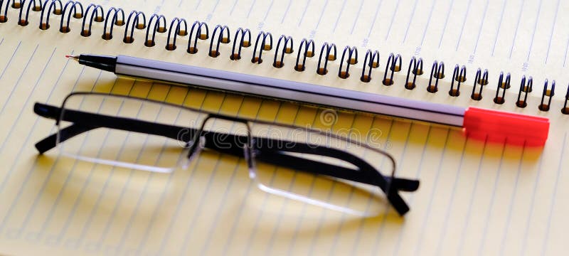 Open the diary a planner, a pencil and glasses on the table closeup stock photo