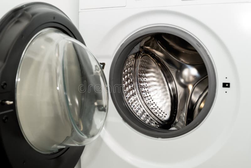 Open Door of Front Load Washing Machine in Laundry Room. Empty Drum of