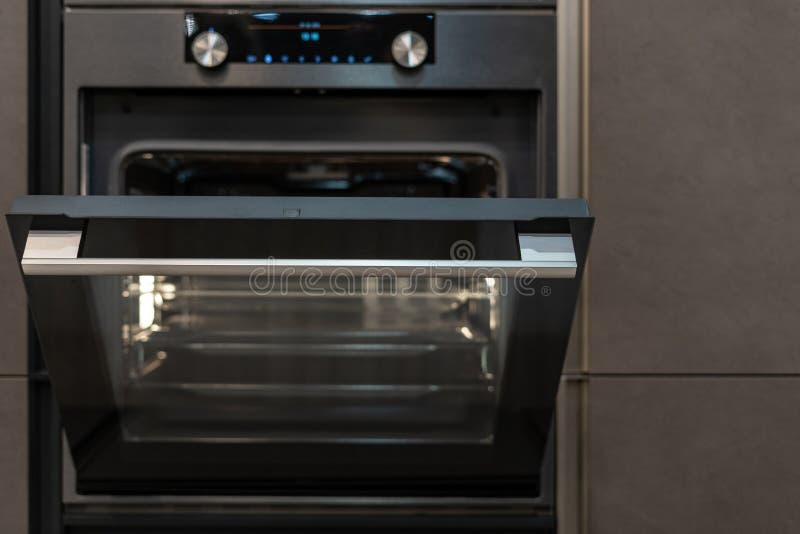 Open Door on Modern Oven Builtin in Kitchen Stock Image