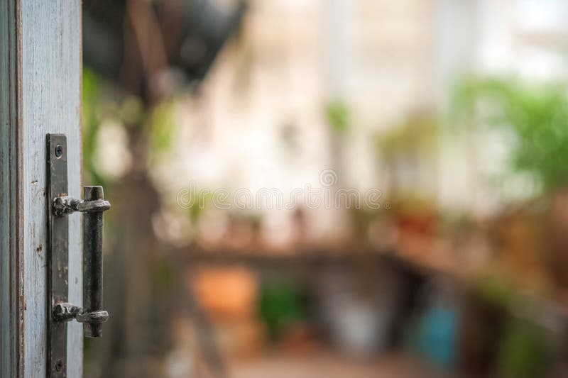 Open door to the greenhouse with vintage handles in rustic style closeup and copy space