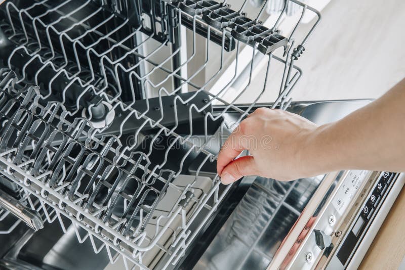 Dishwasher Machine. Woman Hand Taking Out Clean Dish after Washing