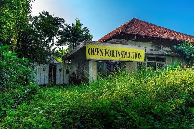 Open for Inspection Plastic Sign Banner in Front of Empty Damage Abandoned House Building with Unattended Garden Full of Grass and