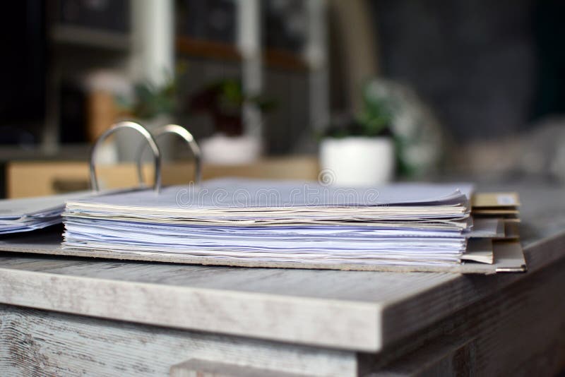 Lever arch file with many pages of documents lying on table with blurry background stock photography Lever arch file with many pages of documents lying on table with blurry background stock photography