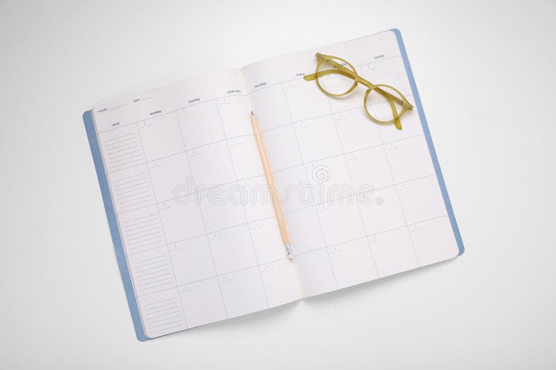 Open monthly planner, glasses and pencil on white background, top view stock image