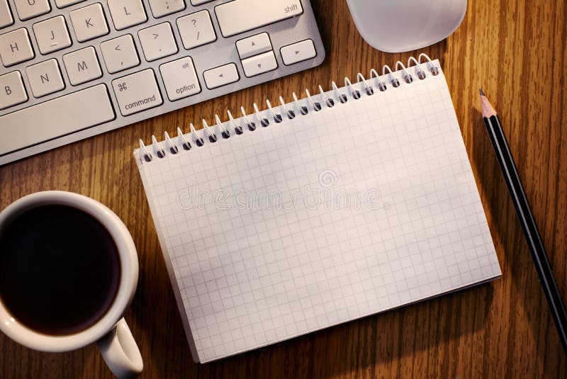 open notebook with coffee alongside a keyboard stock image
