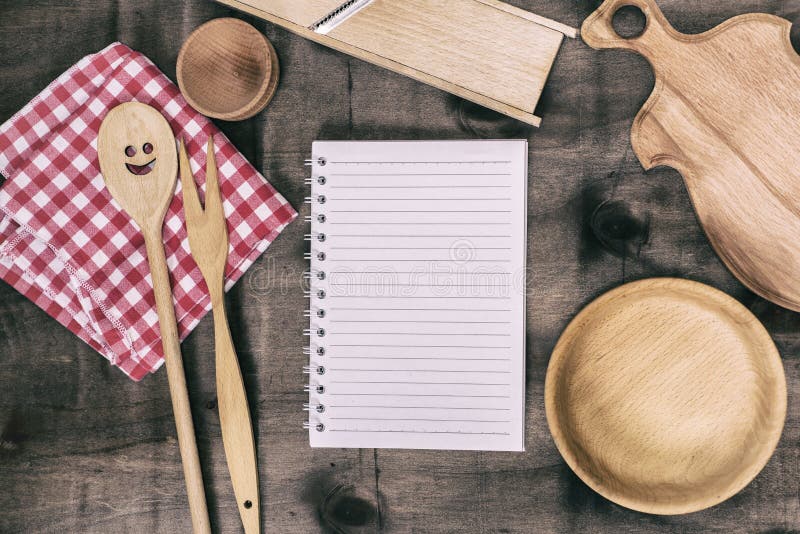 Open notepad with wooden kitchen objects