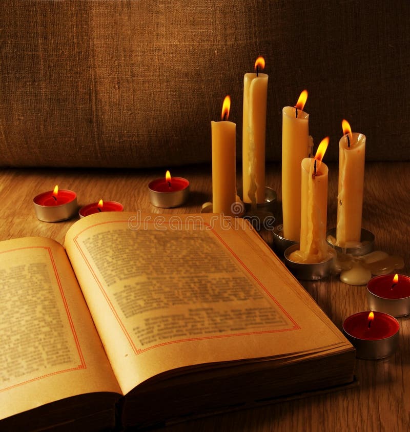 Open Old Book and Burning Candles