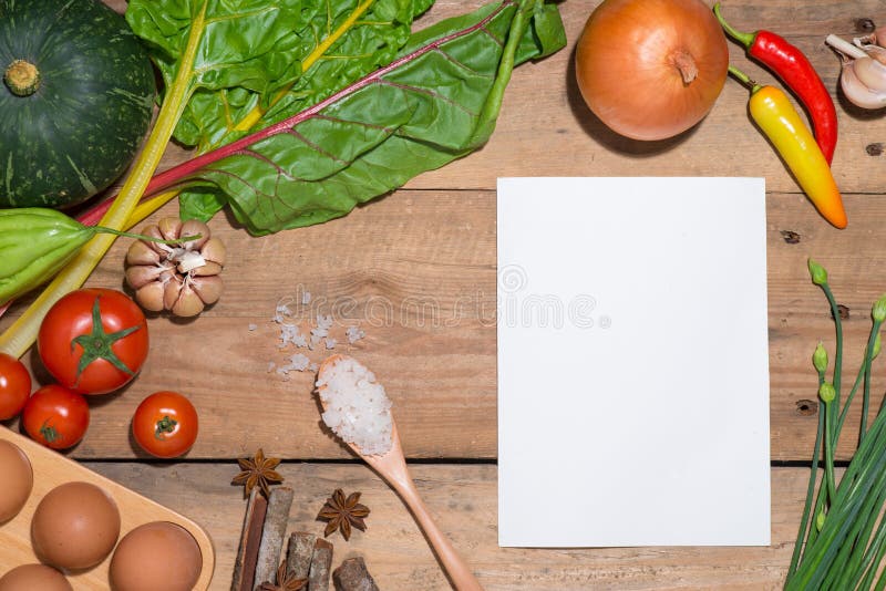 Open Recipe Book with Fresh Vegetables on Wooden Table. Stock Photo