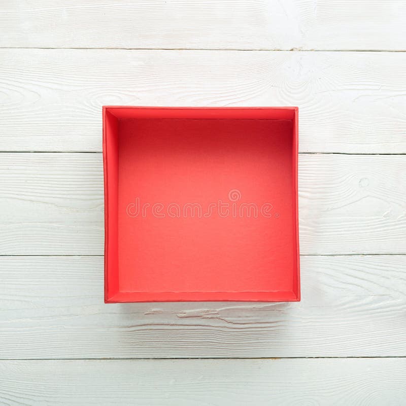 Open red gift box on wooden background