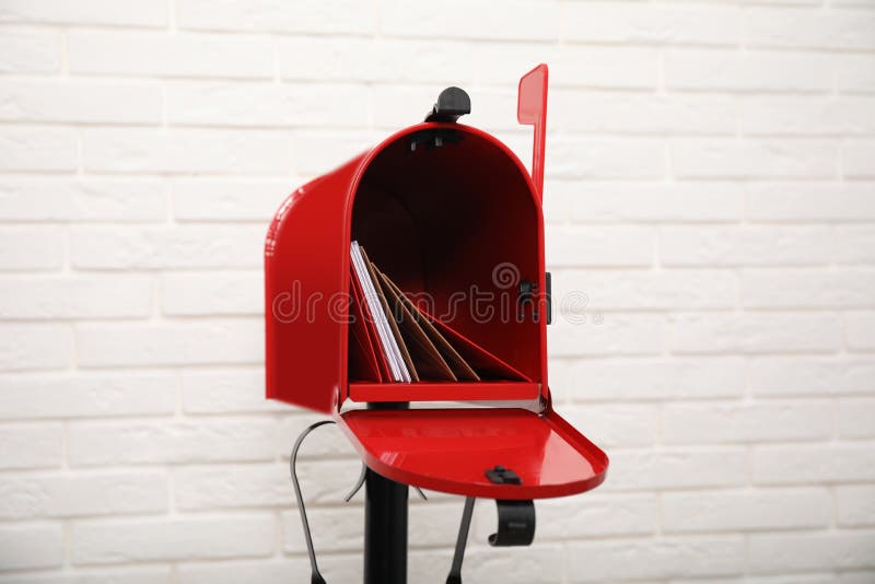 Open Red Letter Box with Envelopes Near White Brick Wall Stock Image