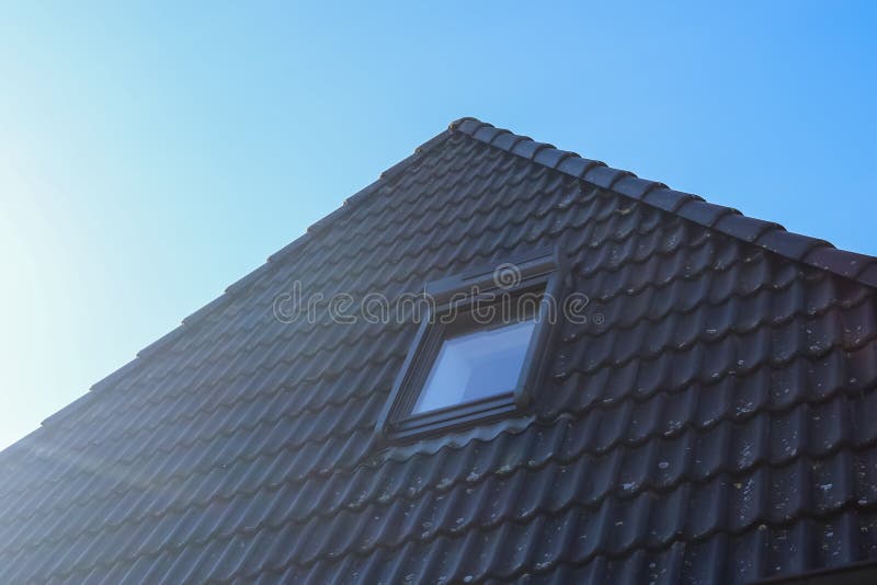 Open Roof Window in Velux Style with Black Roof Tiles Stock Photo