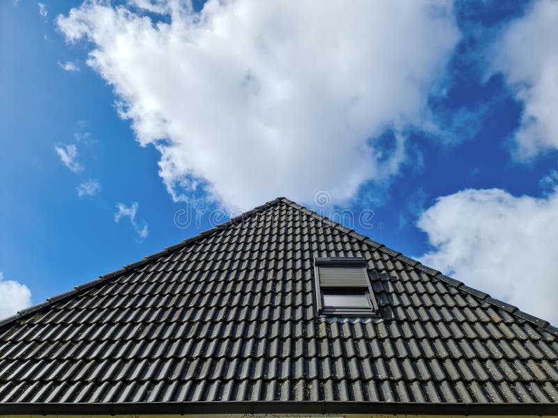 Open Roof Window in Velux Style with Black Roof Tiles Stock Photo