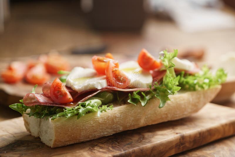 Open Sandwich with Prosciutto, Mozzarella and Tomatoes on Kitchen Table