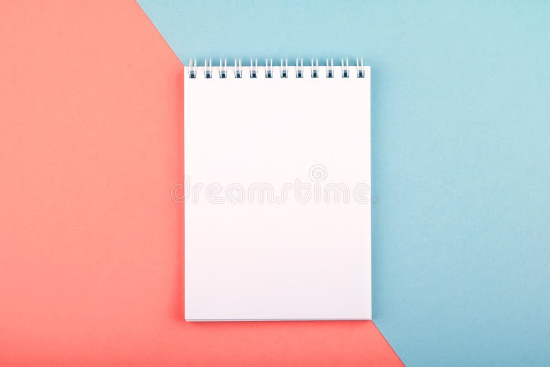 White open notebook with a clean sheet lies on a two-color surface of blue and coral color, top view. Notepad composition stock images, royalty-free photos and pictures