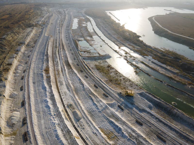 Opencast mining quarry with machinery at work - Aerial view. Industrial Extraction of lime, chalk, calx, caol.