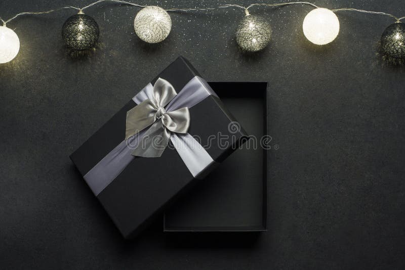 Opened Black Gift Box with Silver Ribbon. Gift on a Black Granite