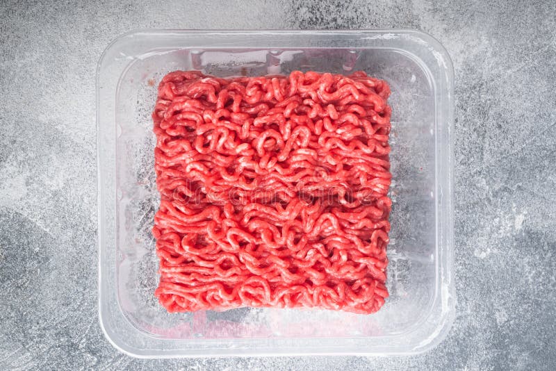 Opened Plastic Tray with Fresh Raw Minced Beef Meat, on Gray Stone