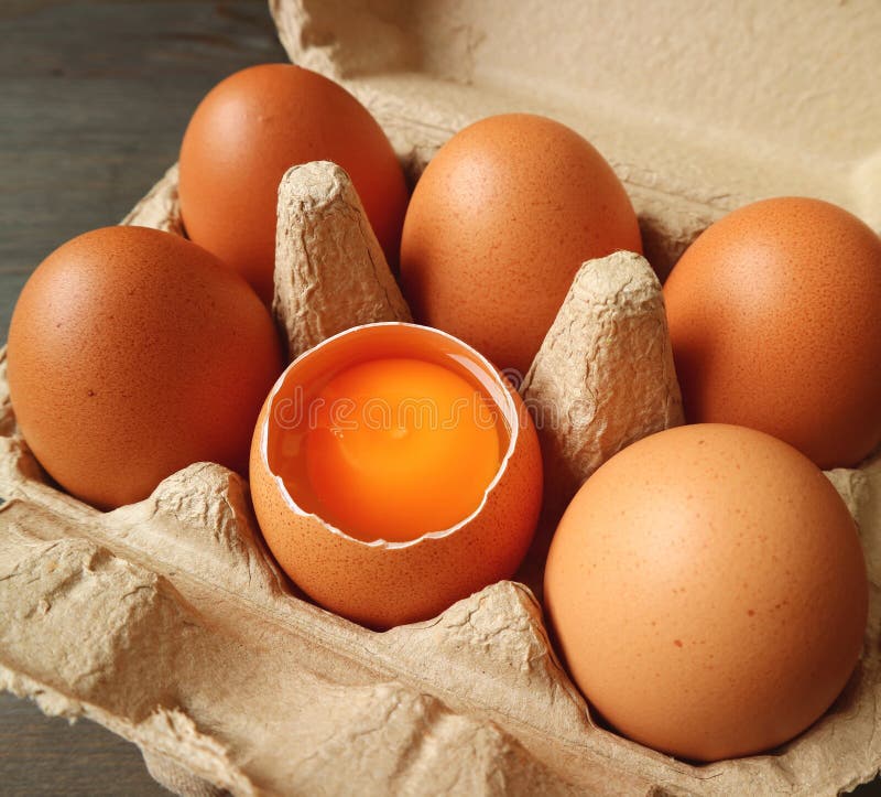 Opened Shell Fresh Organic Egg Showing Egg Yolk in the Carton Box Stock