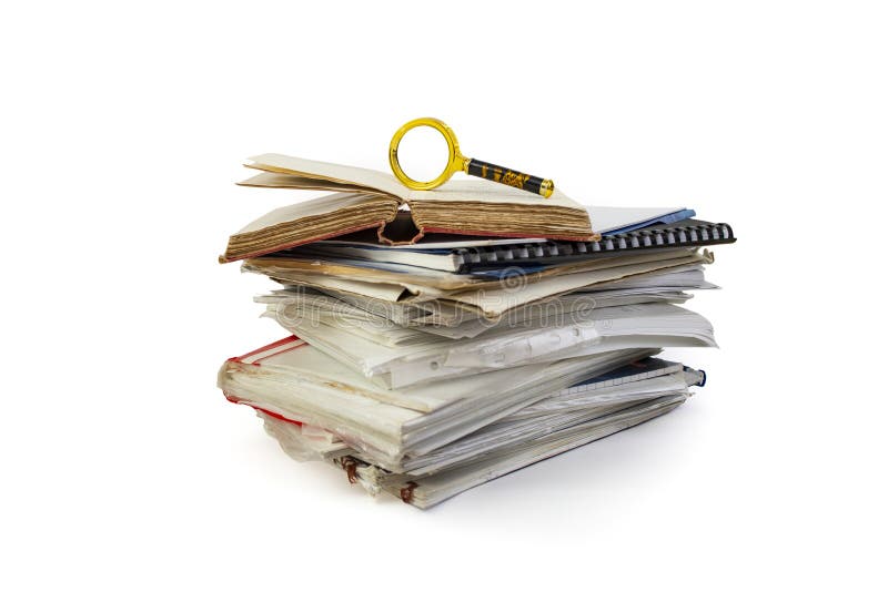 Opened vintage book and a magnifying glass on top of a high stack of folders and documents, isolated on white background royalty free stock photography