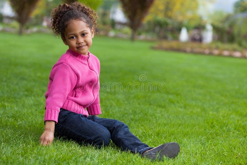 Het portret van een Aanbiddelijk klein Afrikaans Aziatisch meisje zette op stock foto's Het portret van een Aanbiddelijk klein Afrikaans Aziatisch meisje zette op stock foto's