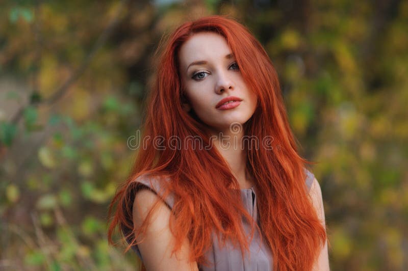 In openlucht portret van mooie jonge vrouw met rood haar stock afbeelding In openlucht portret van mooie jonge vrouw met rood haar stock afbeelding