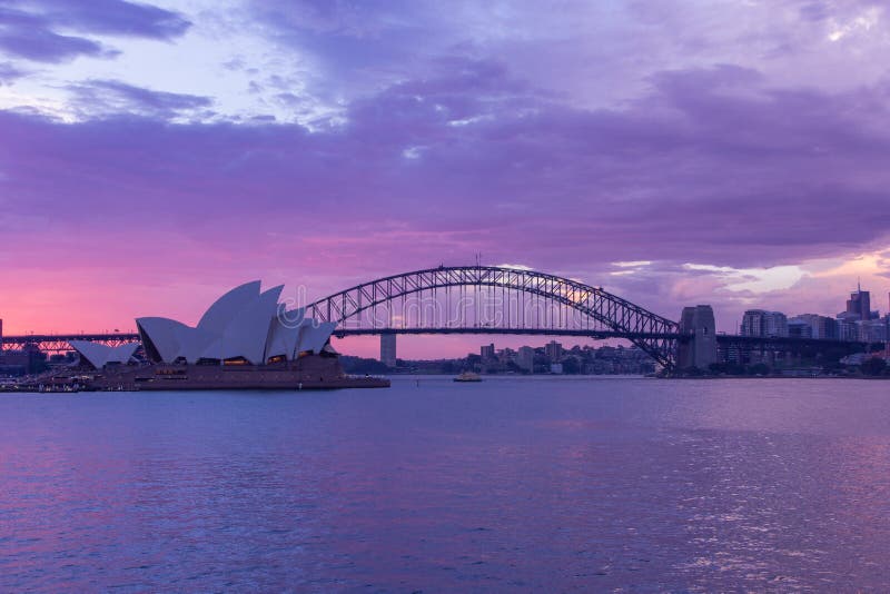 Opera house and harbour bridge in Sydney at sun clouds