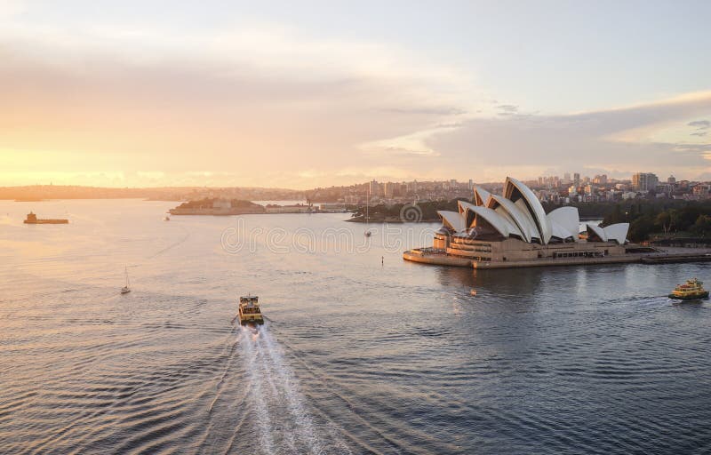 The Opera House, Landmark of Sydney city CBD on Harbour waterfront around Circular Quay in warm light of morning sun under blue s