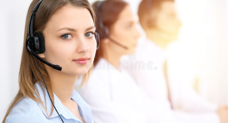 Operadores de centro de atención telefónica Céntrese en mujer sonriente alegre joven en auriculares Conceptos del negocio y del s fotografía de archivo Operadores de centro de atención telefónica Céntrese en mujer sonriente alegre joven en auriculares Conceptos del negocio y del s fotografía de archivo