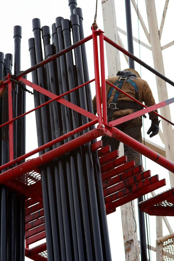 A view looking upwards to an oil worker on scaffolding tending to oily pipes at an oil well in Huntington Beach, California. The well was being reabandoned for the construction of new homes. A view looking upwards to an oil worker on scaffolding tending to oily pipes at an oil well in Huntington Beach, California. The well was being reabandoned for the construction of new homes.