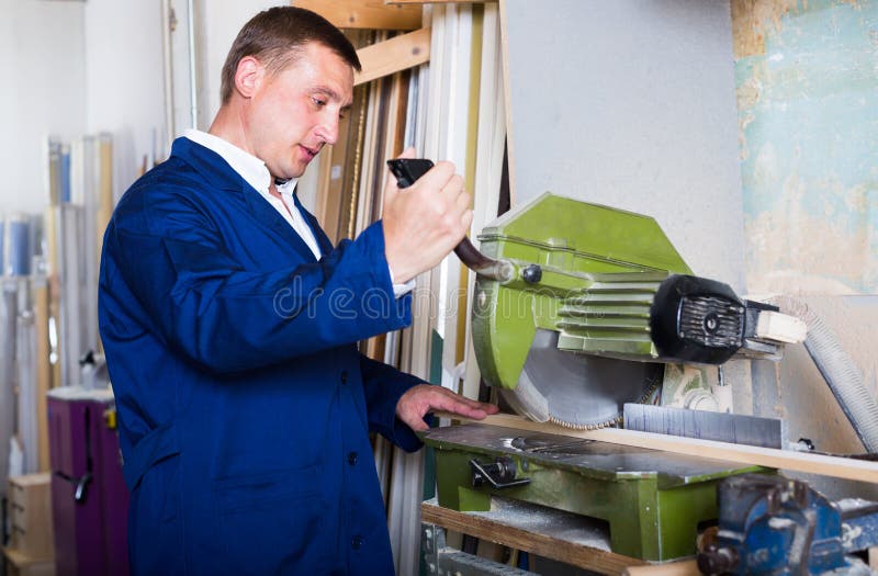 Operaio professionista che taglia le plance di legno facendo uso della sega circolare fotografia stock libera da diritti Operaio professionista che taglia le plance di legno facendo uso della sega circolare fotografia stock libera da diritti