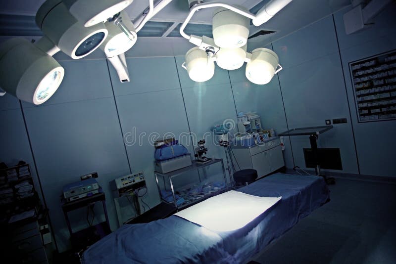 Immagine di una sala operatoria con luci e un letto.